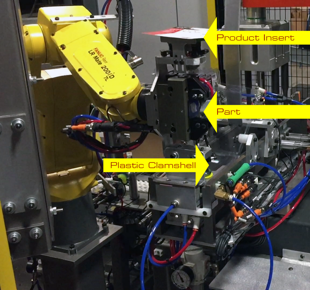 The end of arm tooling is designed to pick all the items for the packaging assembly in a single robot cycle. The tool has a suction cup to select the product insert, a clamp to select the part, and another set of suction cups for the clamshell. 